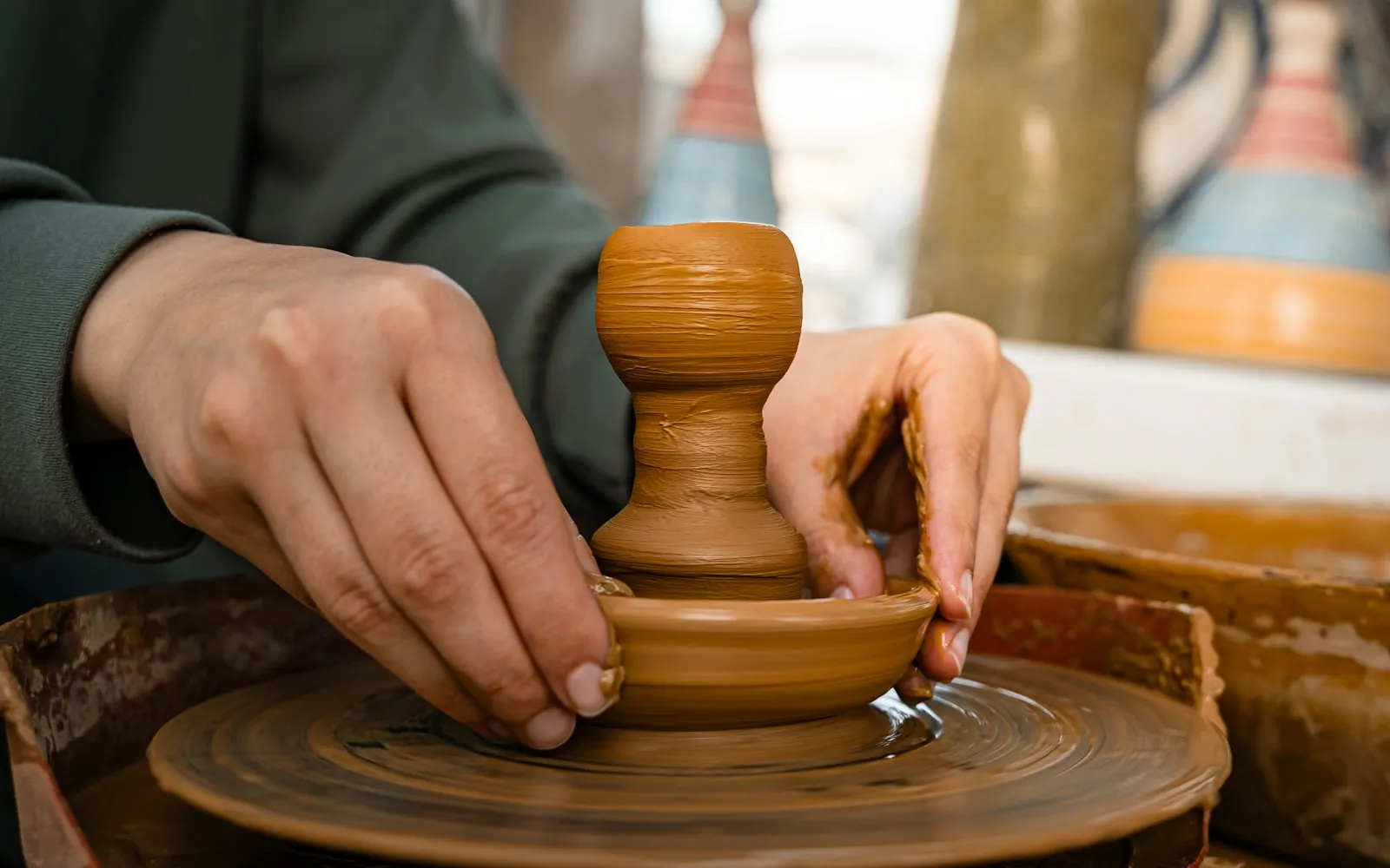 Hands shaping clay on a pottery wheel (sample image)